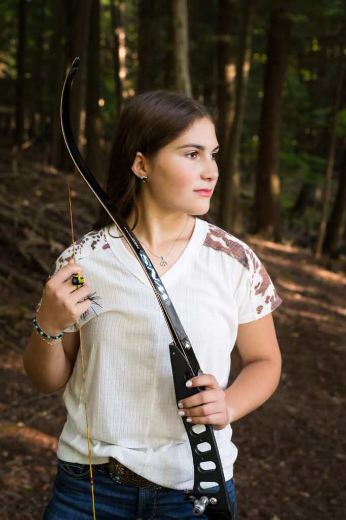 Senior portrait of Bella showing her passion for archery captured by Canton NY High School photographers.